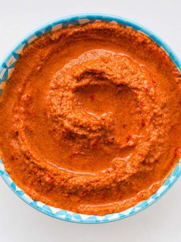 Easy muhammara dip recipe in a bowl with olive oil swirl and smooth texture