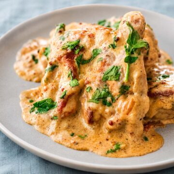 Creamy mustard chicken served on a plate with a rich garlic mustard sauce and fresh parsley garnish