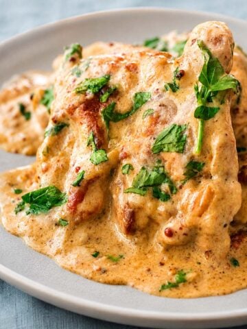 Creamy mustard chicken served on a plate with a rich garlic mustard sauce and fresh parsley garnish