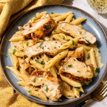 One-Pan Creamy Garlic Parmesan Chicken Pasta Recipe served in a ceramic bowl with golden seared chicken, creamy parmesan sauce, and tender penne pasta.