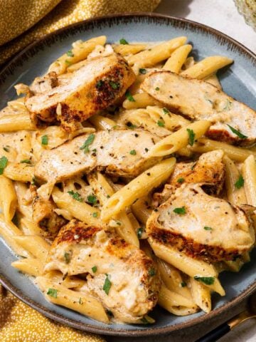 One-Pan Creamy Garlic Parmesan Chicken Pasta Recipe served in a ceramic bowl with golden seared chicken, creamy parmesan sauce, and tender penne pasta.