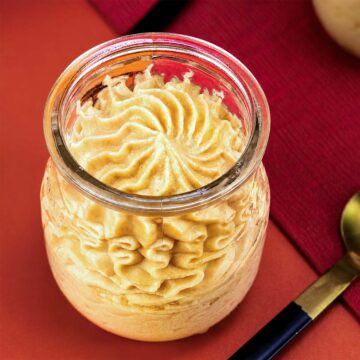 Peanut Butter Mousse piped into a glass jar with a creamy swirled top and spoon