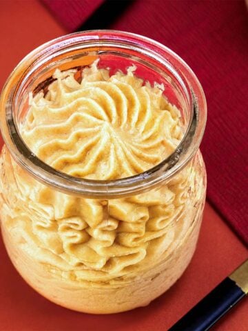 Peanut Butter Mousse piped into a glass jar with a creamy swirled top and spoon
