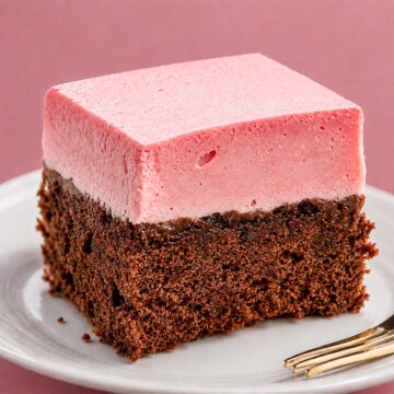 Slice of raspberry mousse chocolate cake with a fluffy pink mousse layer and moist chocolate cake