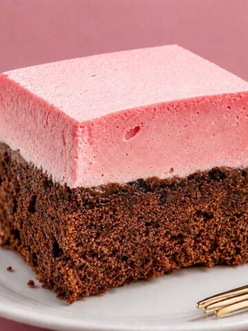 Slice of raspberry mousse chocolate cake with a fluffy pink mousse layer and moist chocolate cake