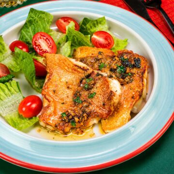 Pan Seared Rock Fish with garlic herb butter sauce served with fresh lettuce and cherry tomatoes
