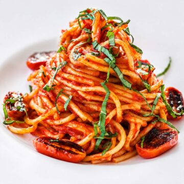 Cherry tomato pasta with roasted blistered tomatoes, fresh basil, and spaghetti in rich homemade tomato sauce