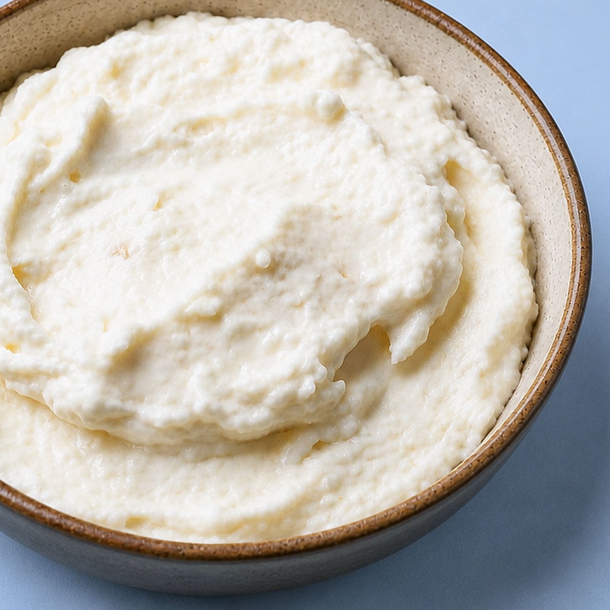 Close up Creamy Toum (Lebanese Garlic Sauce) in a rustic bowl with smooth whipped texture