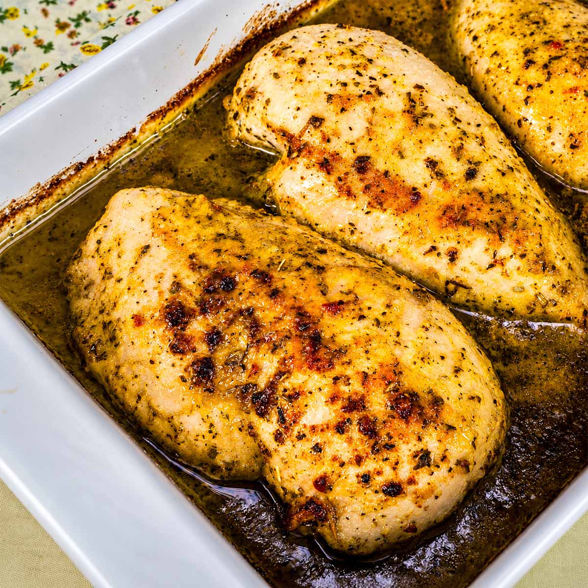Baked Italian dressing chicken breasts in a baking dish, coated in a golden herbed seasoning and ready to serve.