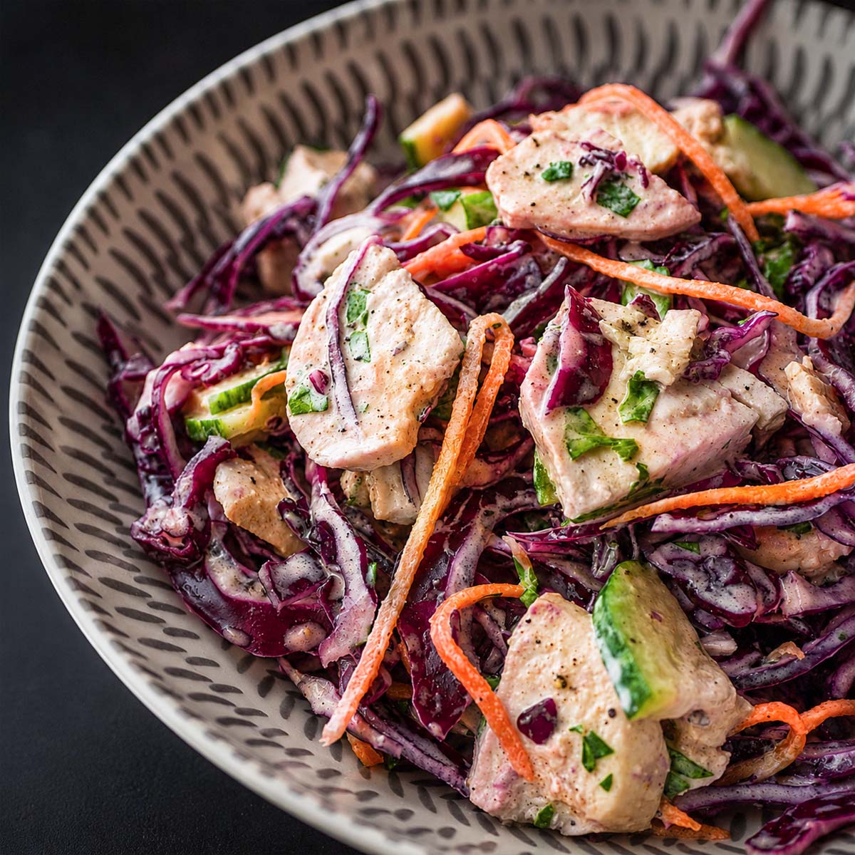 Creamy chicken cabbage salad with red cabbage, cucumber, carrot, and tender chicken pieces in a light dressing