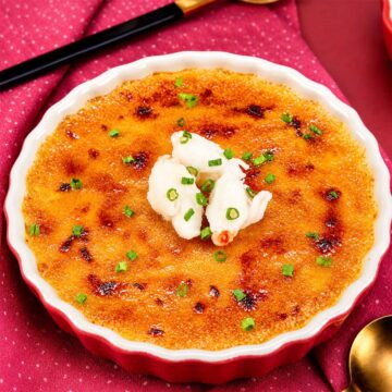 Crab brulee with a caramelized golden crust topped with fresh crab meat and chives