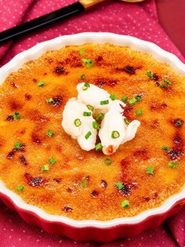 Crab brulee with a caramelized golden crust topped with fresh crab meat and chives