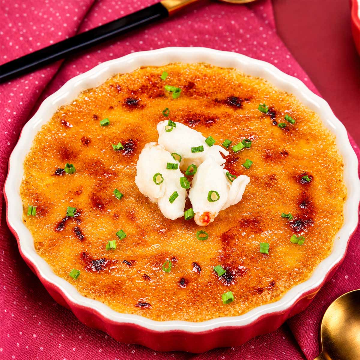 Crab brulee with a caramelized golden crust topped with fresh crab meat and chives