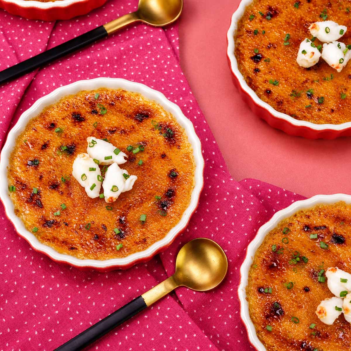 3 Crab brulee in ramekins with a caramelized golden crust topped with fresh crab meat and chives