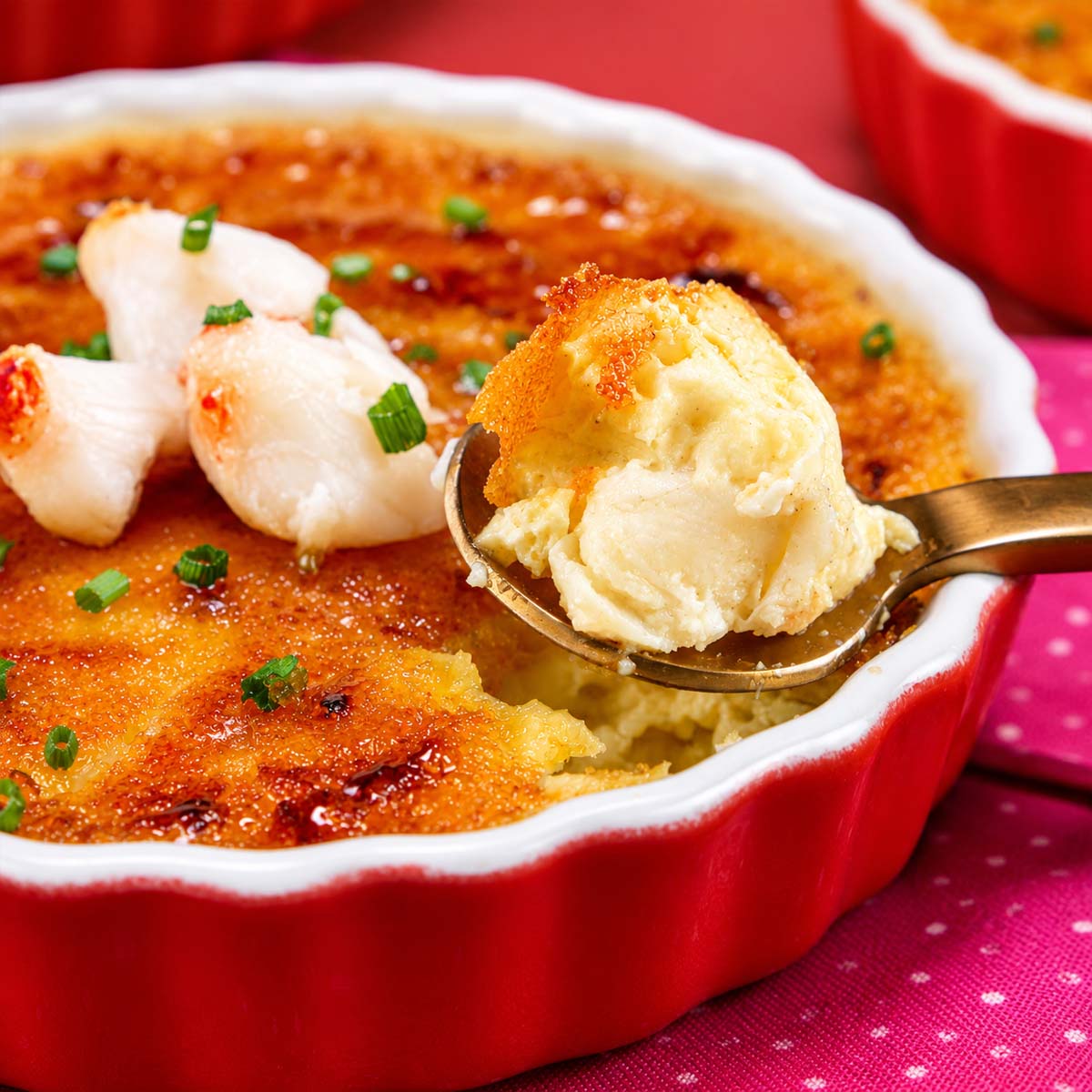 Soon scooping crab brulee from the ramekin with a caramelized golden crust topped with fresh crab meat and chives