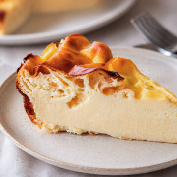 Slice of 4-ingredient yogurt cake on a white plate, with a golden-brown top and soft, creamy custard-like center.