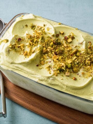 No-churn avocado ice cream topped with chopped pistachios in a loaf pan