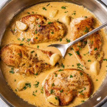One-pan creamy garlic chicken with juicy pan-seared chicken breasts in a rich garlic cream sauce with whole garlic cloves