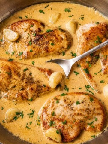 One-pan creamy garlic chicken with juicy pan-seared chicken breasts in a rich garlic cream sauce with whole garlic cloves
