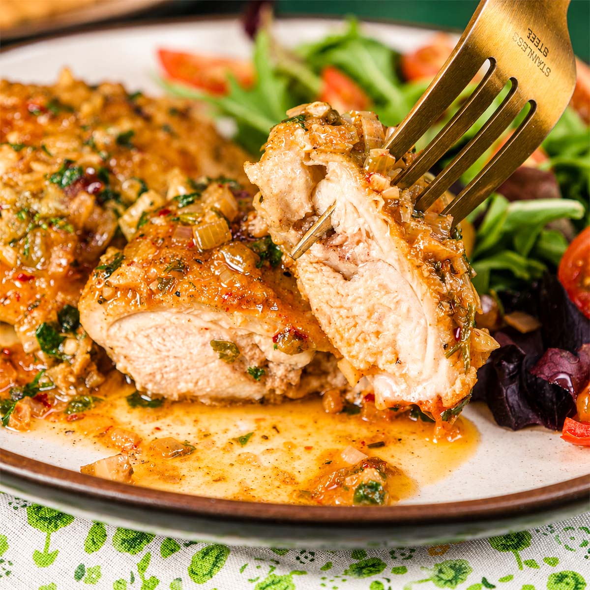 Juicy garlic butter chicken thighs with tender sliced chicken lifted on a fork, showing the inside texture.