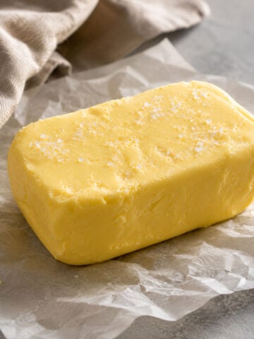 Homemade butter made from heavy cream sprinkled with flaky sea salt on parchment paper