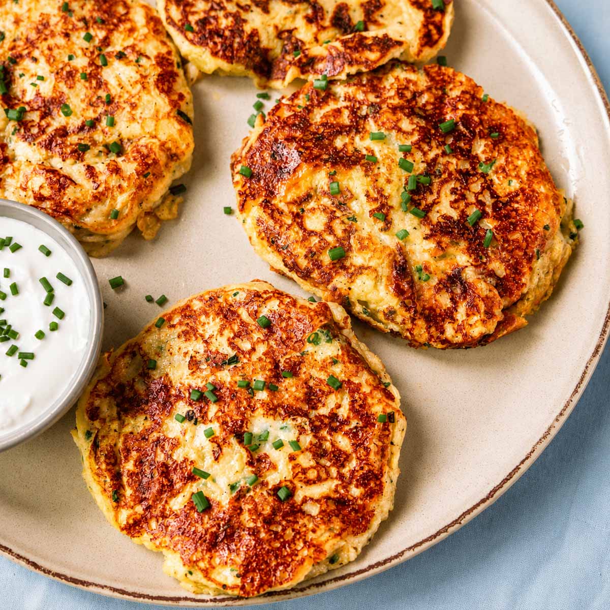Close-up of crispy leftover mashed potato pancakes with golden crust and creamy sour cream dip