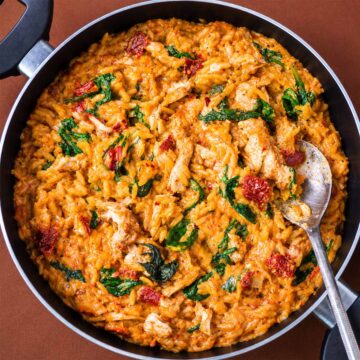Creamy Marry Me chicken orzo with spinach and sun-dried tomatoes in a skillet