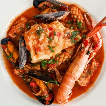 Spanish seafood stew with white fish, mussels, squid, and langoustine in tomato broth