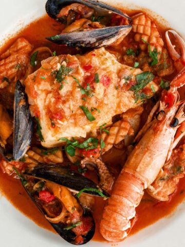 Spanish seafood stew with white fish, mussels, squid, and langoustine in tomato broth