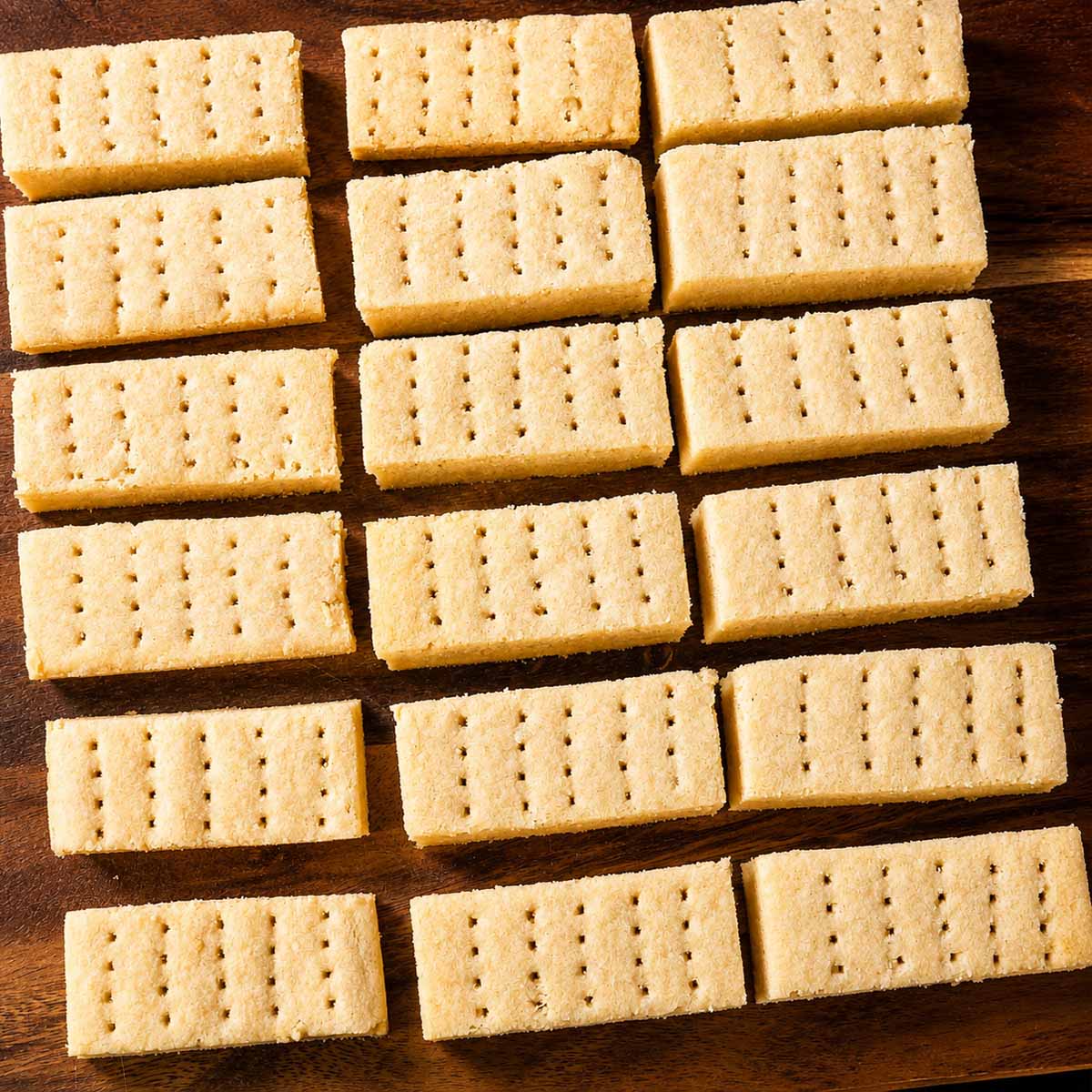 Traditional shortbread cookies arranged on a wooden board showing thick buttery biscuit fingers ready to serve