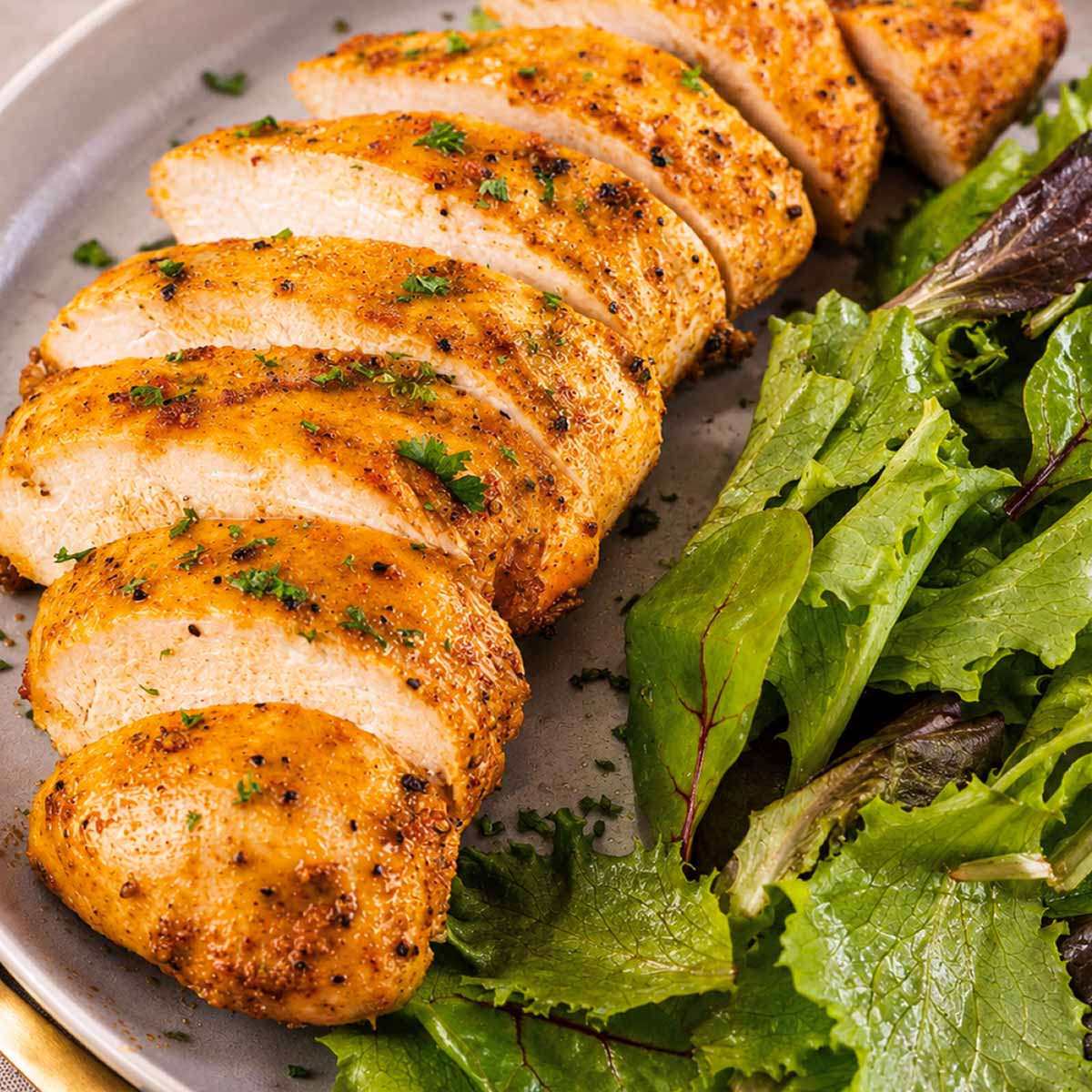 Sliced baked chicken breast served with fresh mixed green salad