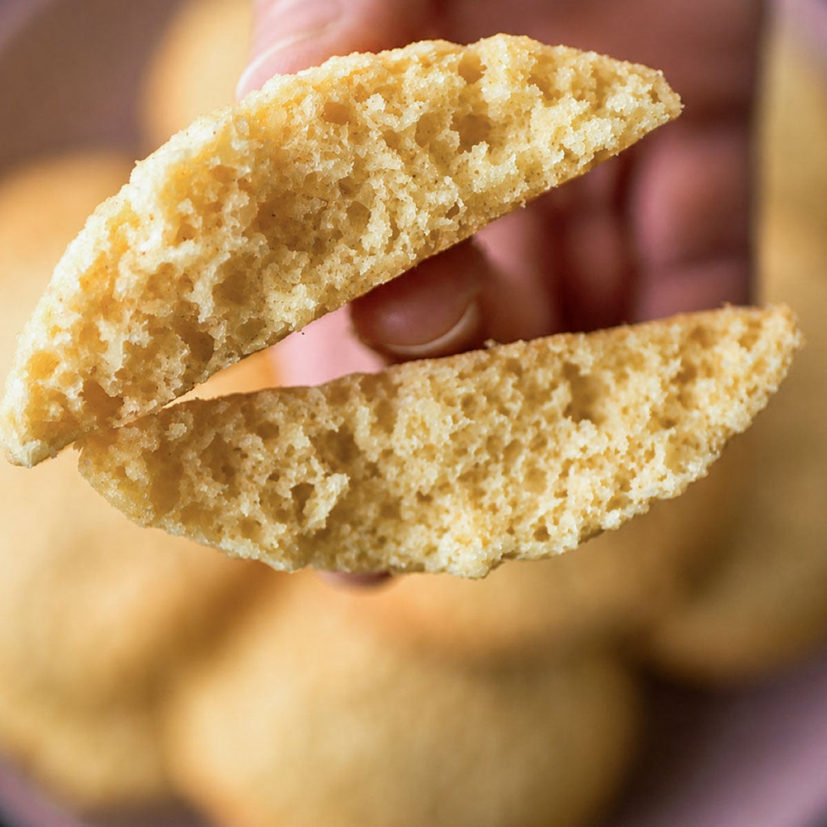 Easy coconut cookie broken in half to show the soft, airy interior and tender coconut crumb