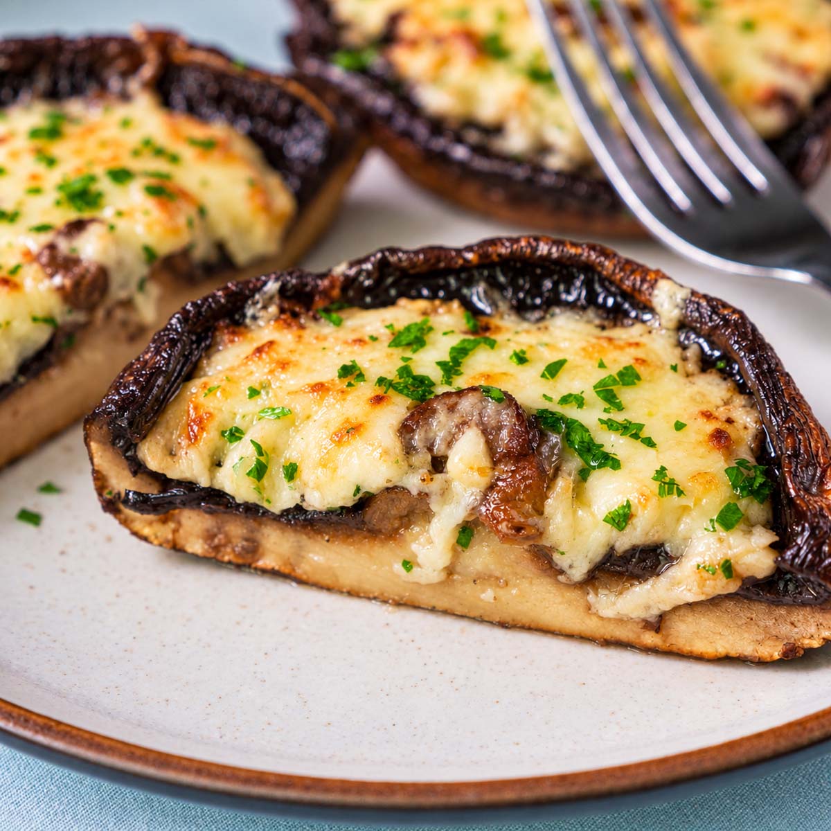 Cut baked portobello mushroom showing the tender mushroom and melted cheese filling