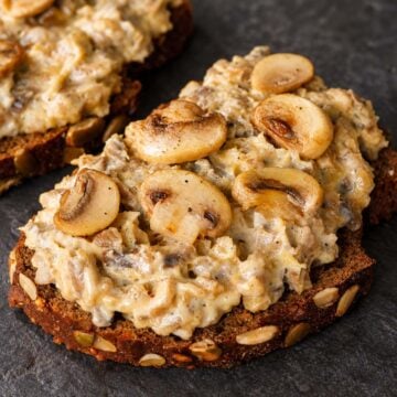 Seeded sourdough toast topped with creamy chopped mushrooms and golden sautéed mushroom slices.