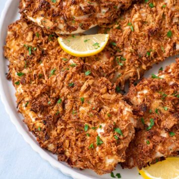 Golden baked French onion chicken breasts with crunchy onion flakes and chopped parsley.