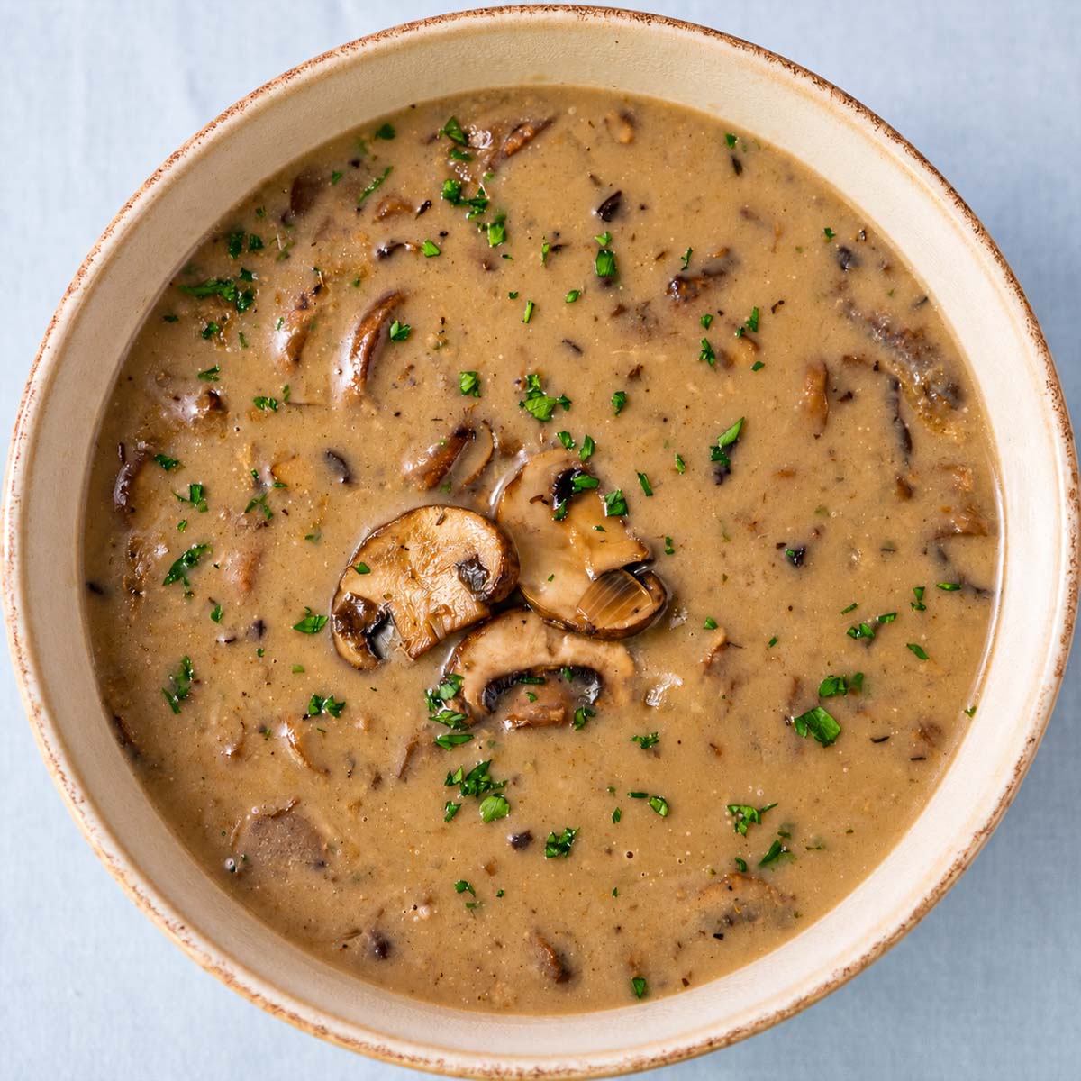 Creamy mushroom soup without cream topped with sautéed mushrooms and fresh parsley.
