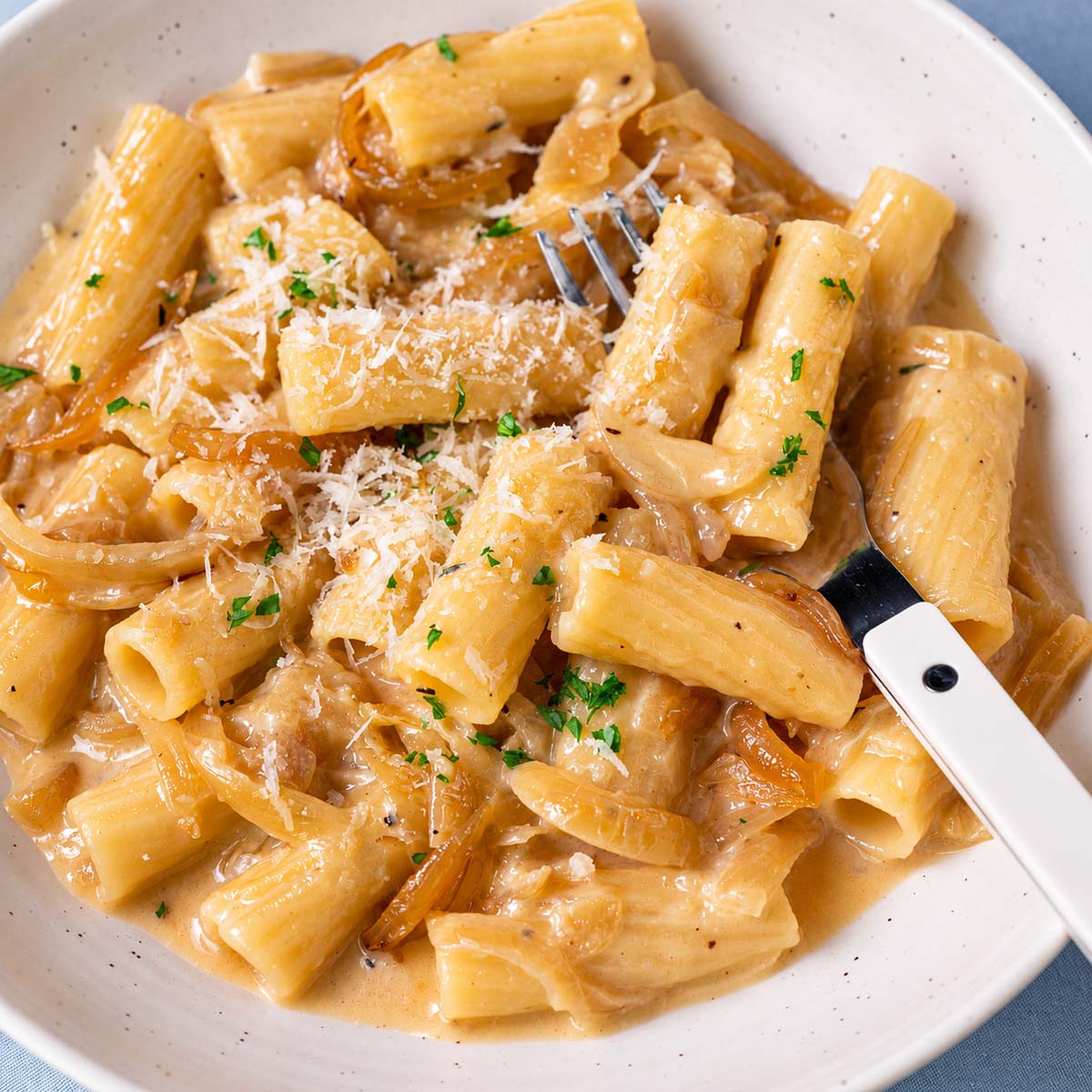 Bowl of one pot French onion pasta with creamy sauce, caramelized onions and grated Parmesan

Four steps for making one pot French onion pasta with caramelized onions, rigatoni, broth and