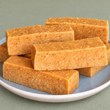 Turrón de Jijona bars stacked on a gray ceramic plate