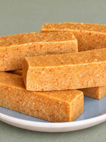 Turrón de Jijona bars stacked on a gray ceramic plate